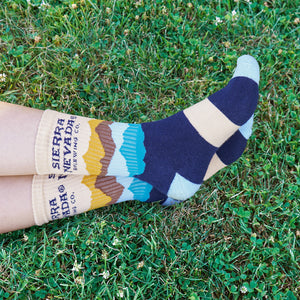 Thumbnail of A person wears a pair of Sierra Nevada Mountain Range Socks outside in a grassy field