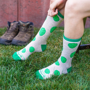 Thumbnail of A person pulls on a pair of Sierra Nevada Hop Socks as a pair of hiking boots sits ready in the background