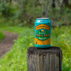 Thumbnail of Sierra Nevada Brewing Co. Trail Pass Hazy IPA can perched on top of a wooden fence post next to a hiking trail