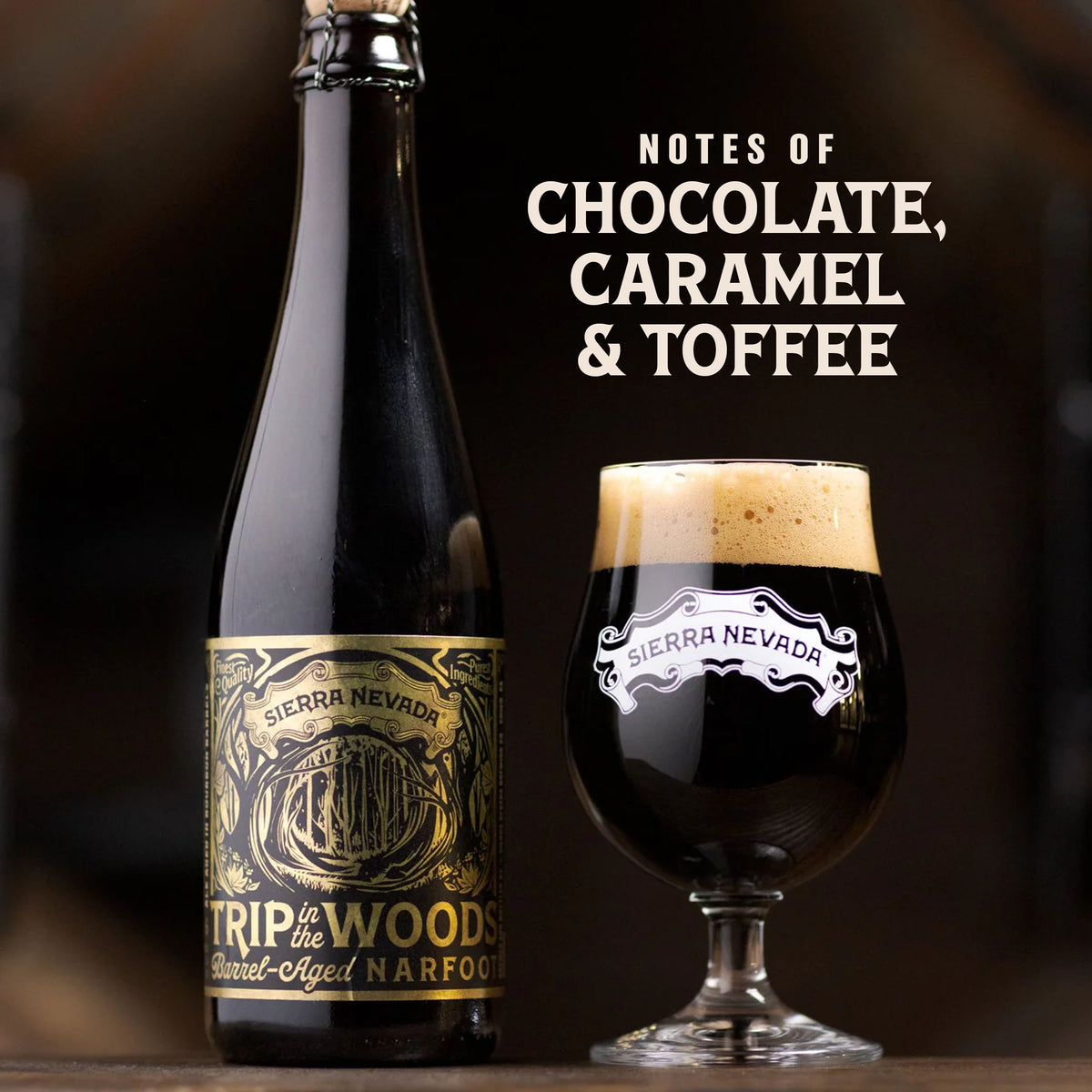 A dark beer bottle labeled Sierra Nevada Trip to the Woods barrel-aged narcan alongside a stemmed glass of the same dark beer with a thick cream head, on a wooden surface with the text 'NOTES OF CHOCOLATE, CARAMEL & TOFFEE' on a dark background.