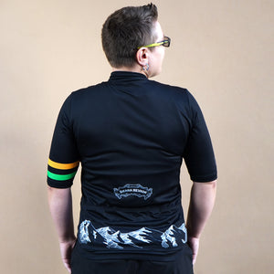 Thumbnail of Person wearing a black cycling jersey with colorful stripes on the back against a beige background