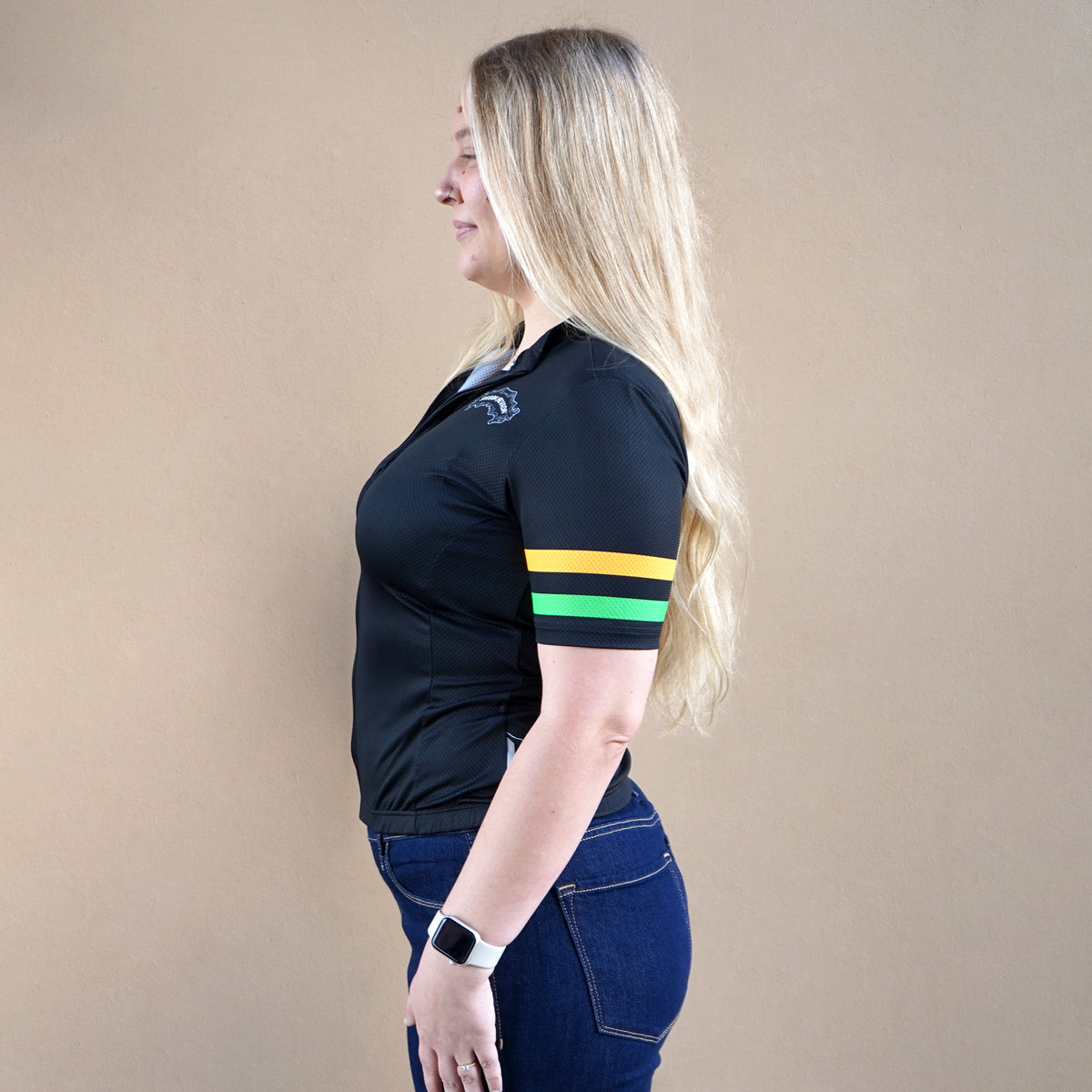 Woman wearing a black polo shirt with colorful stripes on a beige background