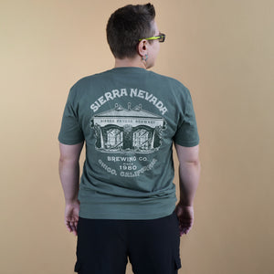 Thumbnail of Person wearing a green t-shirt with Sierra Nevada Brewing Co. logo on the back against a beige background