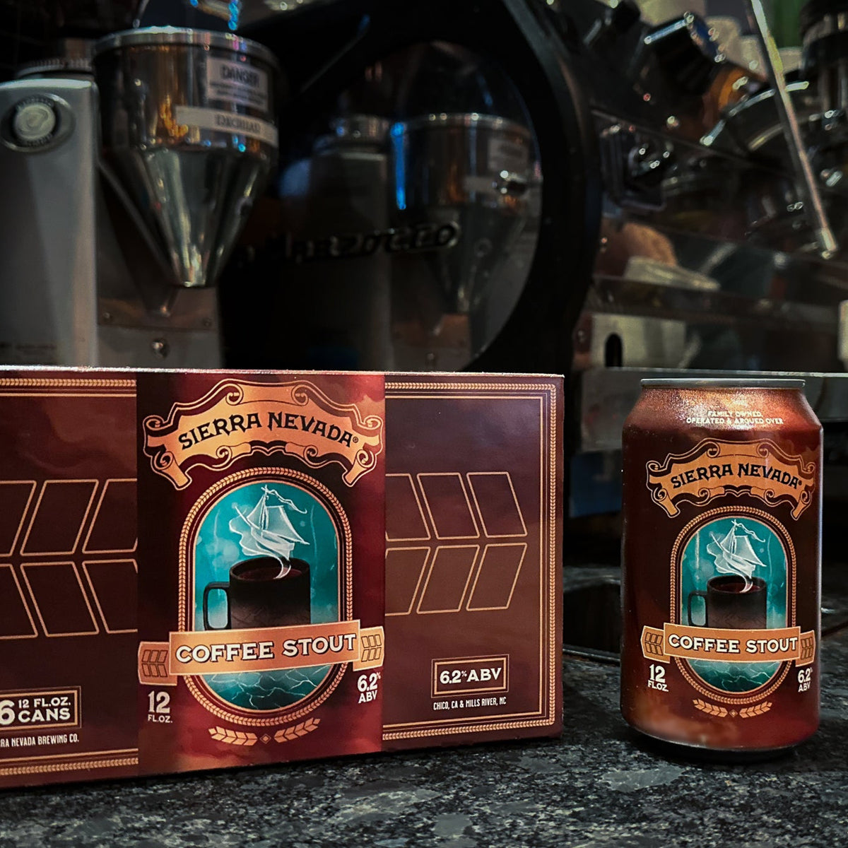 Sierra Nevada Coffee Stout can sitting next to a 6-pack box with coffee roasting equipment in the background