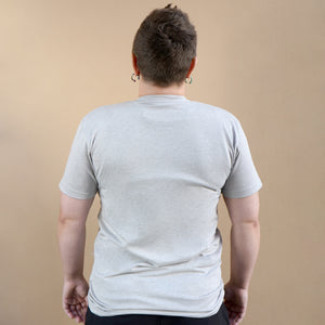 Thumbnail of Person wearing a plain gray t-shirt against a beige background