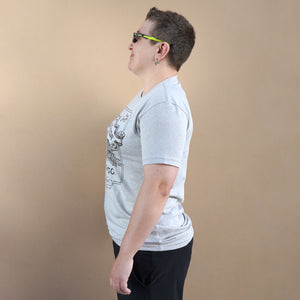 Thumbnail of Person wearing a gray t-shirt with a graphic design on a beige background