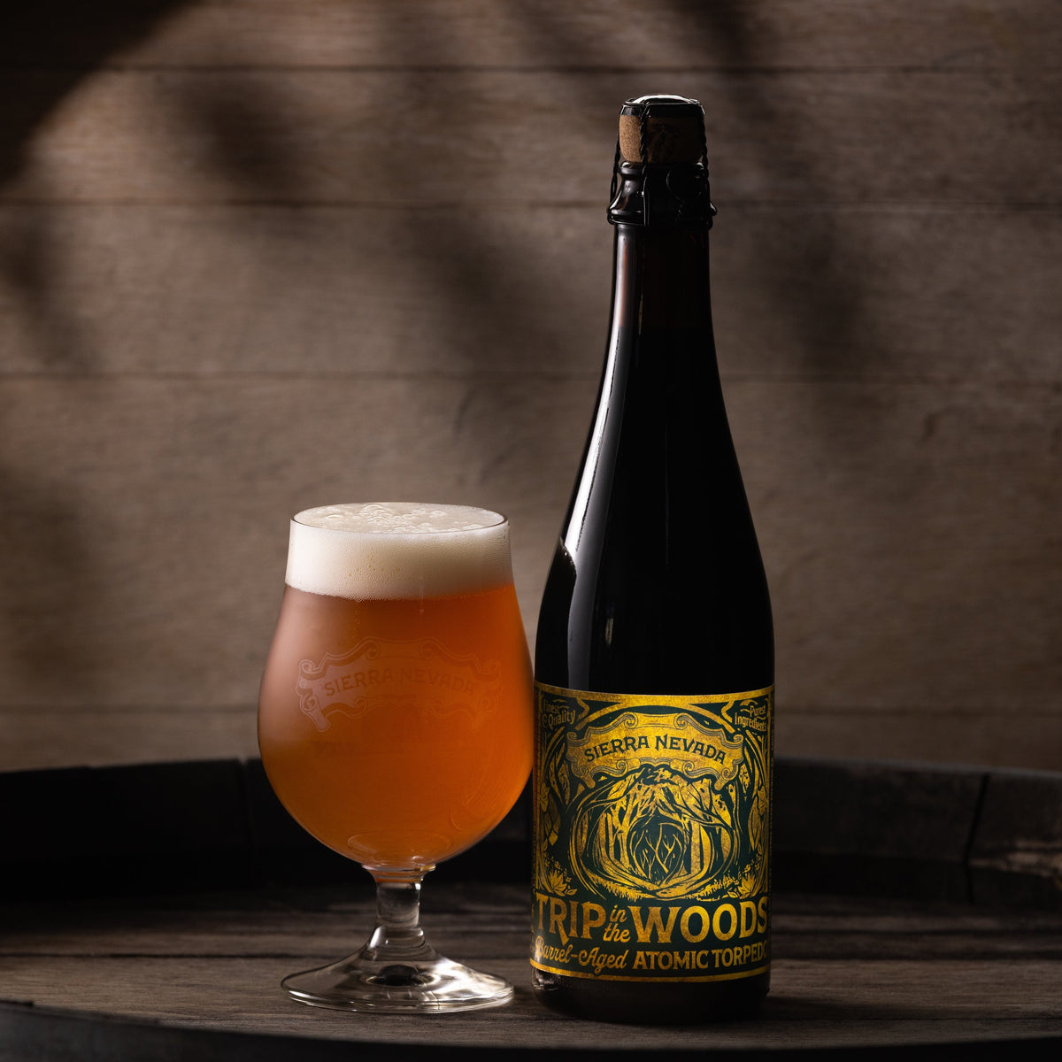 Bottle and glass of Sierra Nevada Trip In The Woods beer on a wooden surface with a dark background