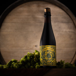 Thumbnail of Bottle of Sierra Nevada Trip in the Woods beer with a label in front of a wooden barrel.