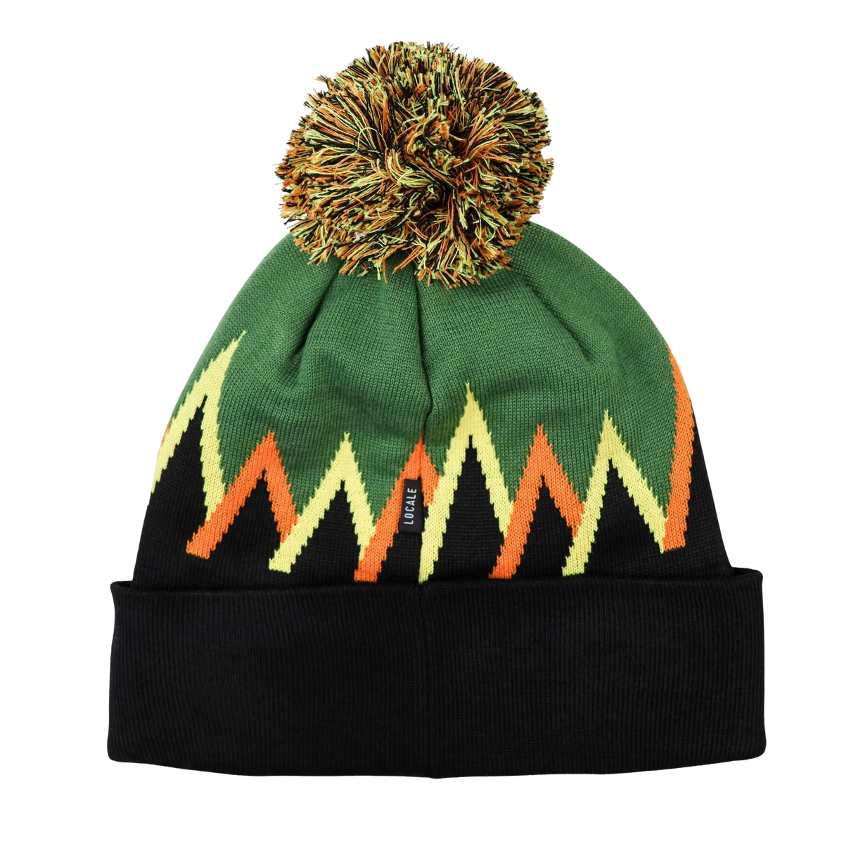 A knit beanie hat with a black cuff, a green top section, and a zigzag pattern in yellow, orange, and black. It features a fluffy pom-pom on top and a small black brand tag on the side.