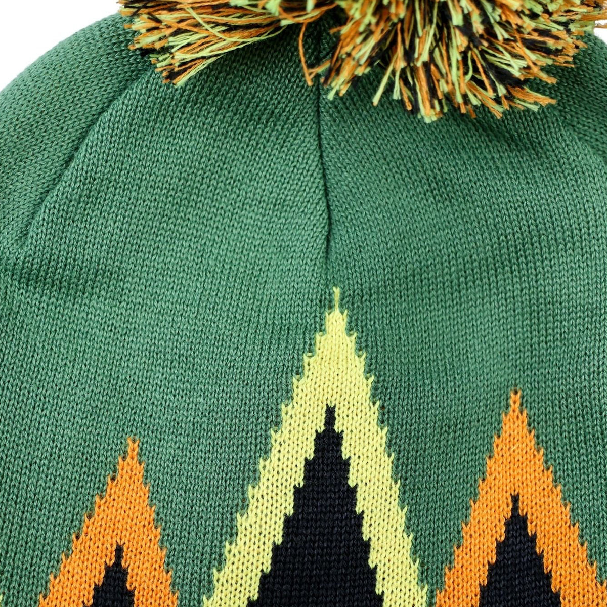 Green knit beanie with mountain design and pom-pom on a white background