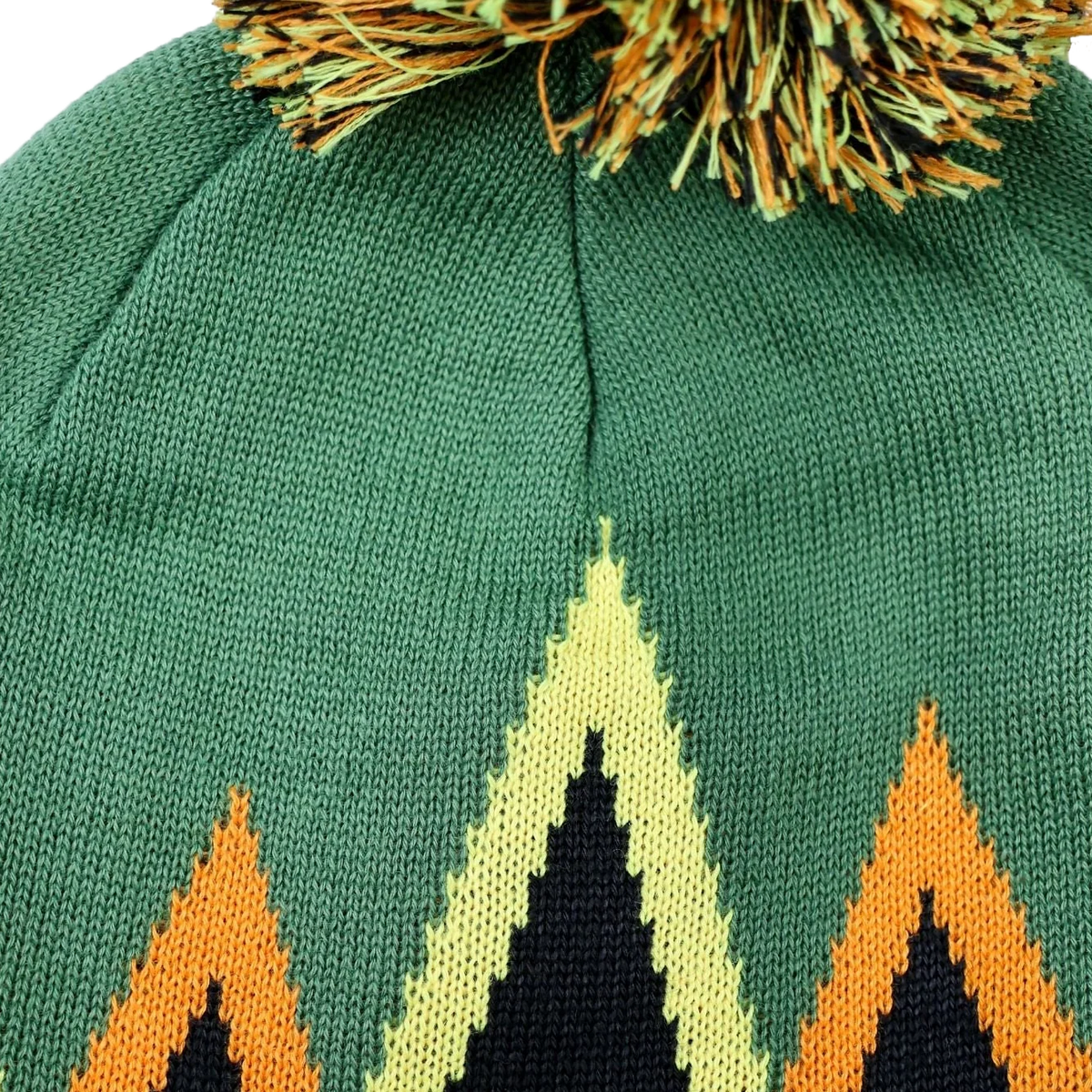Close-up of a green knit beanie with a multicolor geometric mountain pattern and a matching pom-pom on top.