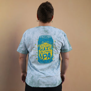 Thumbnail of Person wearing a light blue t-shirt with a graphic design on the back against a beige background
