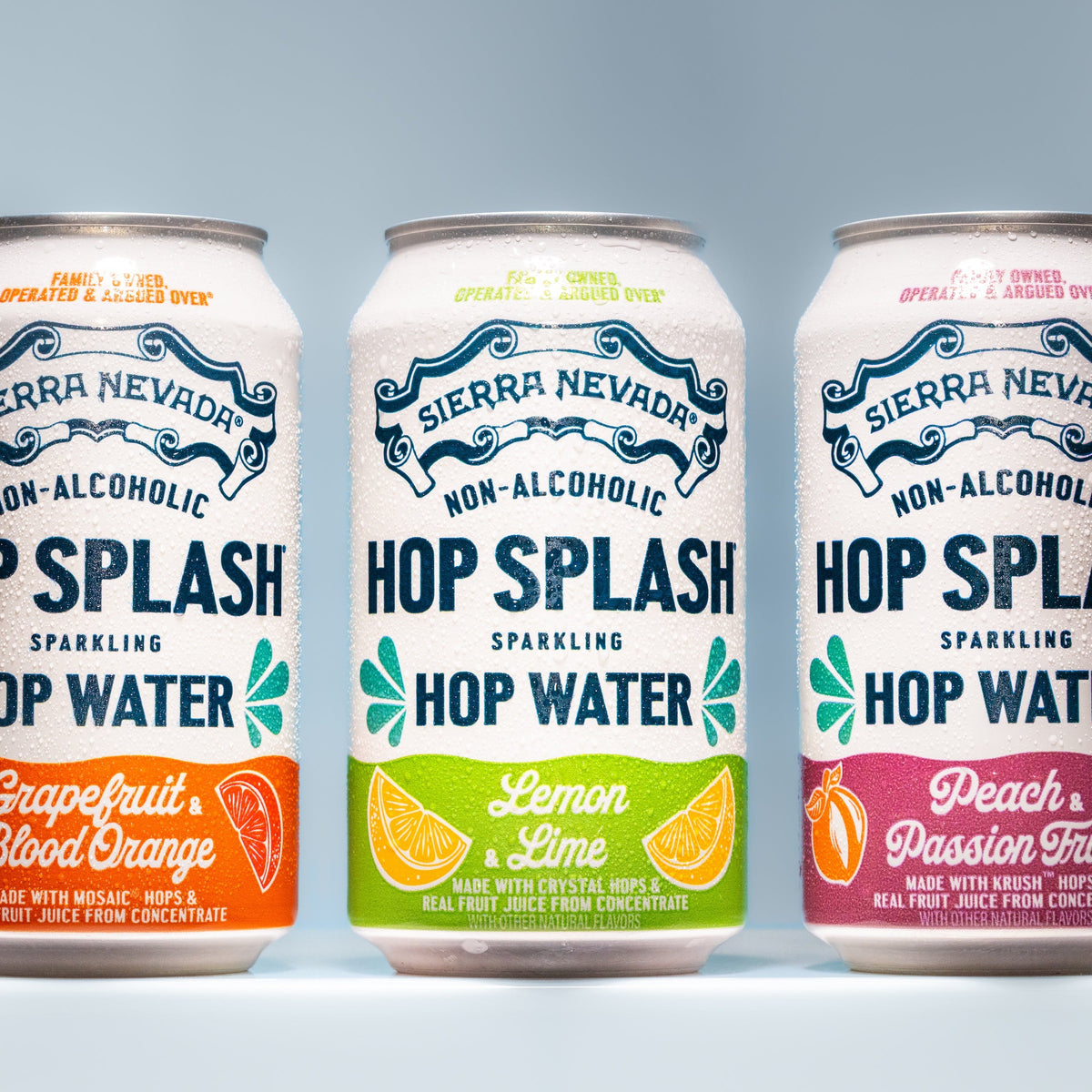 Three cans of Sierra Nevada Hop Splash Non-Alcoholic Hop Water on a light blue background