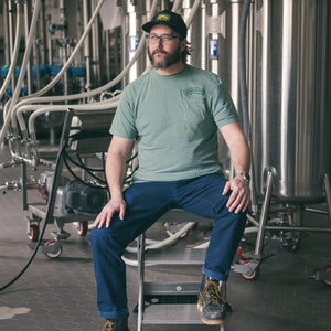 Thumbnail of Man sitting on a ladder in a brewery setting