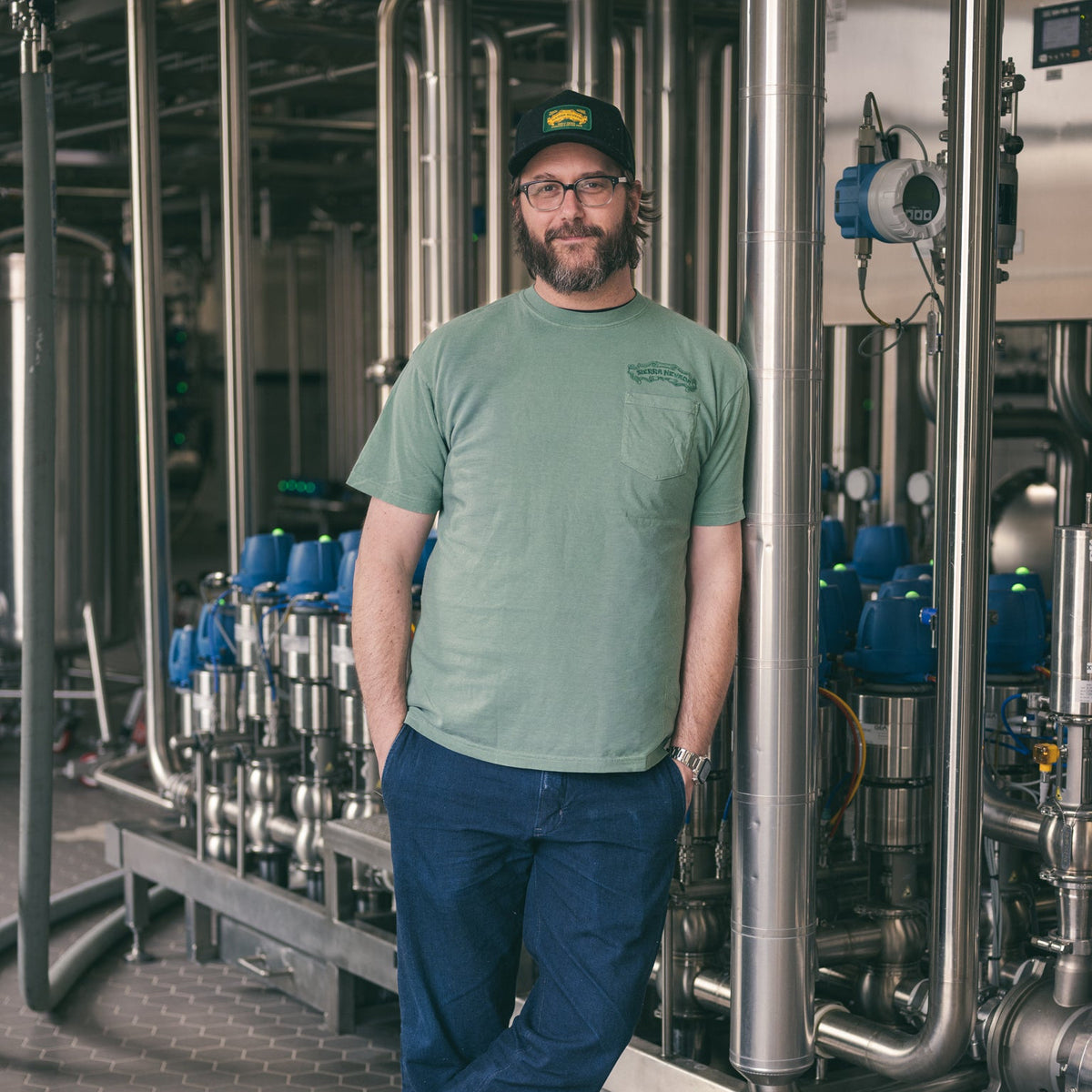 Man standing in a brewery with industrial equipment