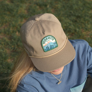Thumbnail of Person wearing a beige cap with Yosemite National Park patch in a grassy area