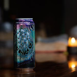 Thumbnail of Can with artistic design on a wooden table with candles in the background