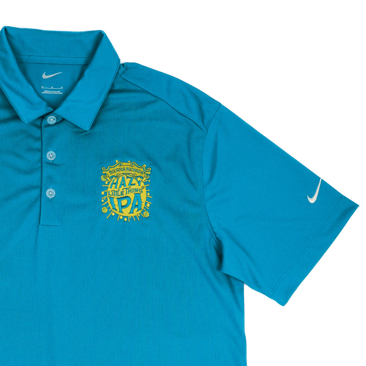 Blue polo shirt with yellow text and Nike logo on a white background
