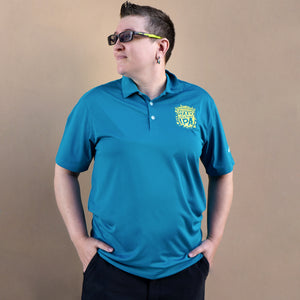 Thumbnail of Person wearing a blue polo shirt with a logo on a beige background