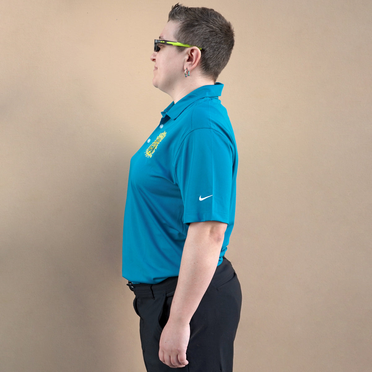 Person wearing a blue Nike polo shirt against a beige background