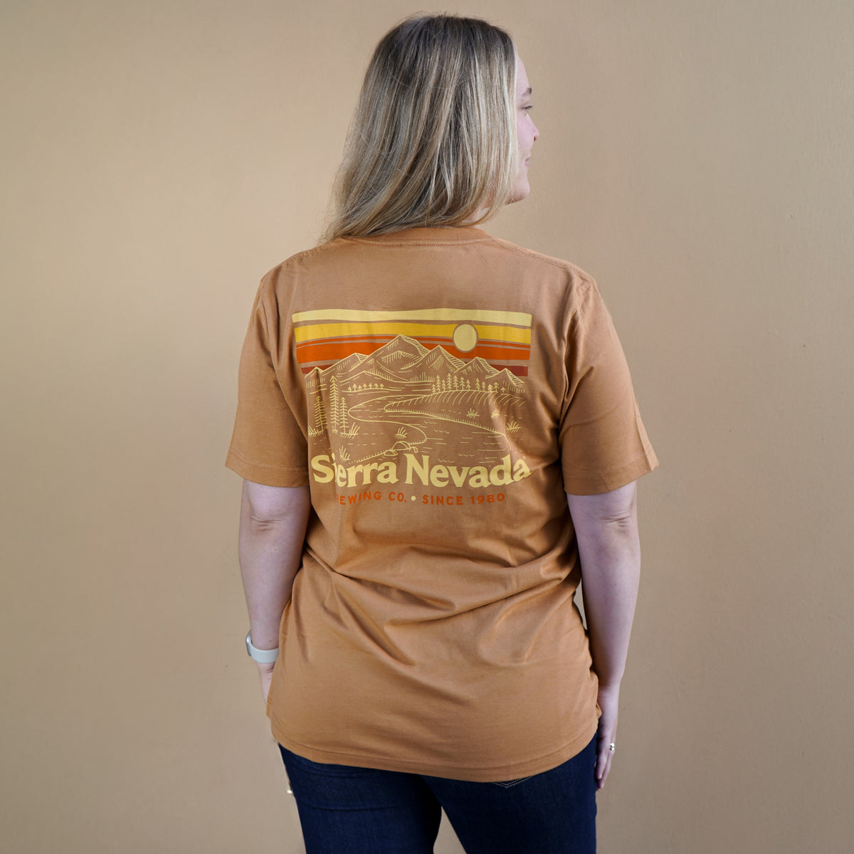Person wearing a brown t-shirt with 'Sierra Nevada' graphic on a beige background