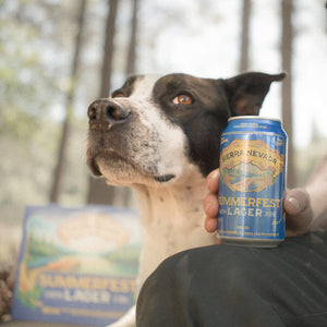 Thumbnail of Person holding a can of Sierra Nevada Summerfest Ale with a dog in a forest setting