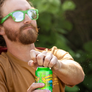 Thumbnail of Man in green Pale Ale sunglasses holding a can of Sierra Nevada in a natural setting