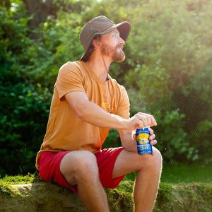 Thumbnail of Man sitting outdoors holding a can, surrounded by greenery