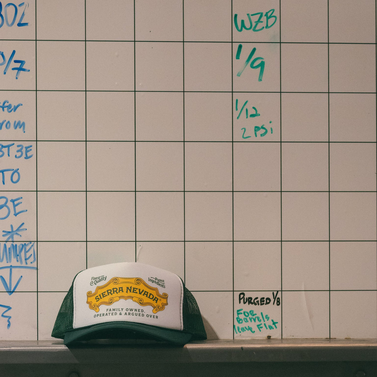 Scorecard with handwritten notes and a Sierra Nevada cap on a table