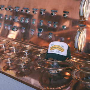 Thumbnail of Green and white cap on a copper beer tap display