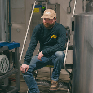 Thumbnail of Man sitting on a metal staircase in an industrial setting