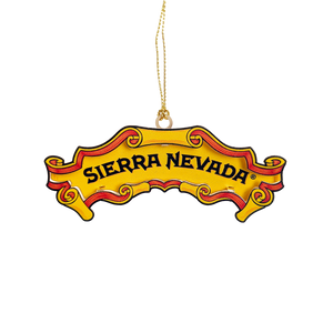 Thumbnail of A novelty Christmas ornament shaped like a vintage Sierra Nevada beer label, featuring a yellow background with red and black scrollwork and the words 'SIERRA NEVADA' in black. A gold hanging loop is attached at the top, shown against a plain white background.