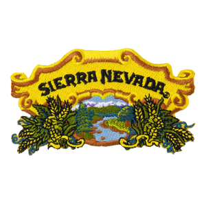 Thumbnail of An embroidered patch featuring the text 'SIERRA NEVADA' in black letters on a yellow scroll, with a scenic landscape of green trees, blue water, and yellow hops or hops-like plants below.