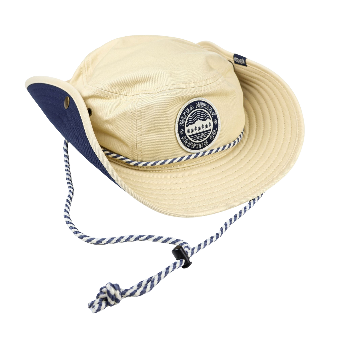 Beige bucket hat with blue interior and strap on a white background