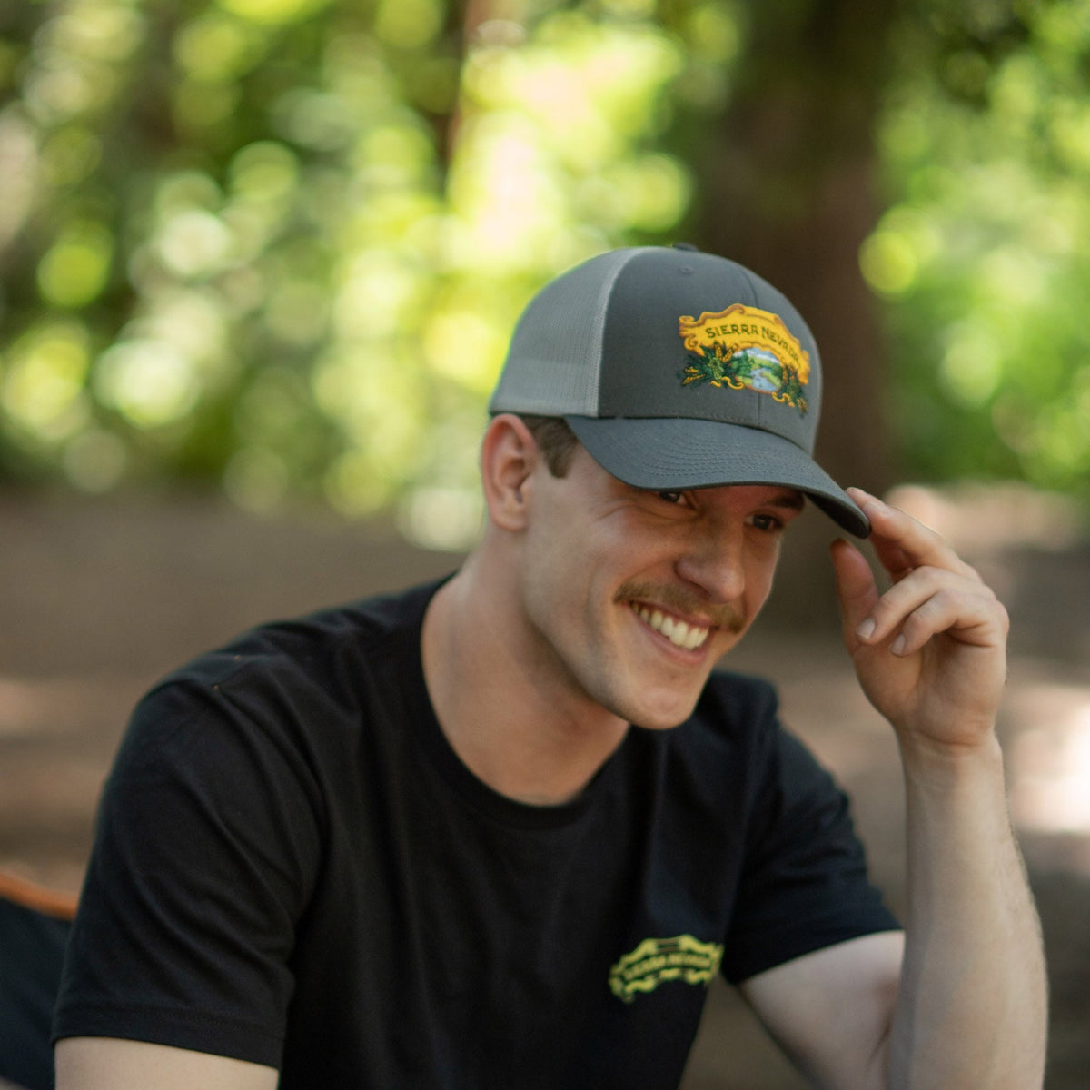Sierra Nevada Brewing Co. Grey Trucker Hat worn by a man in a campground