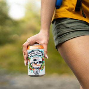Thumbnail of Sierra Nevada Brewing Co. Hop Splash Citrus Non-Alcoholic Sparkling Hop Water - A female hiker carries a can of refreshing Hop Splash Citrus in her hand