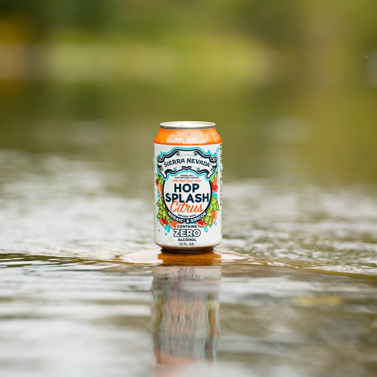 Sierra Nevada Brewing Co. Hop Splash Citrus Non-Alcoholic Sparkling Hop Water - A can of refreshing Hop Splash Citrus sits on a flat stone surrounded by a gently moving river