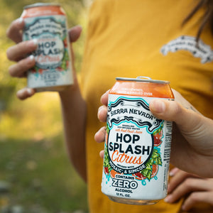 Thumbnail of Sierra Nevada Brewing Co. Hop Splash Citrus Non-Alcoholic Sparkling Hop Water - Two friends hold cold cans of Hop Splash Citrus