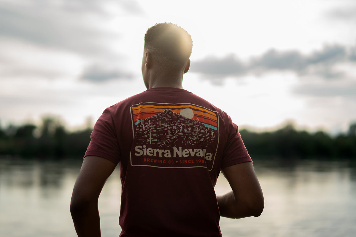 Sierra Nevada Brewing Co. Men's Trail T-Shirt back view worn by a man overlooking a scenic river.