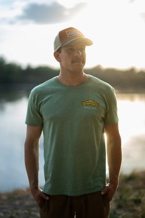 Thumbnail of A man wears the Sierra Nevada Pale Ale T-Shirt while standing alongside a river.
