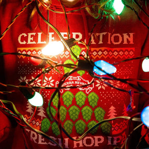 Thumbnail of A person wearing a Celebration IPA sweatshirt with colorful Christmas lights wrapped around their upper body