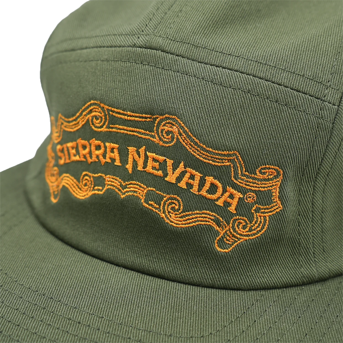 Close-up of an olive green baseball cap with orange embroidered 'SIERRA NEVADA' text and decorative scrollwork on the front panel.