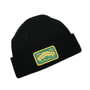 Thumbnail of Black beanie with a gold and green label on a white background