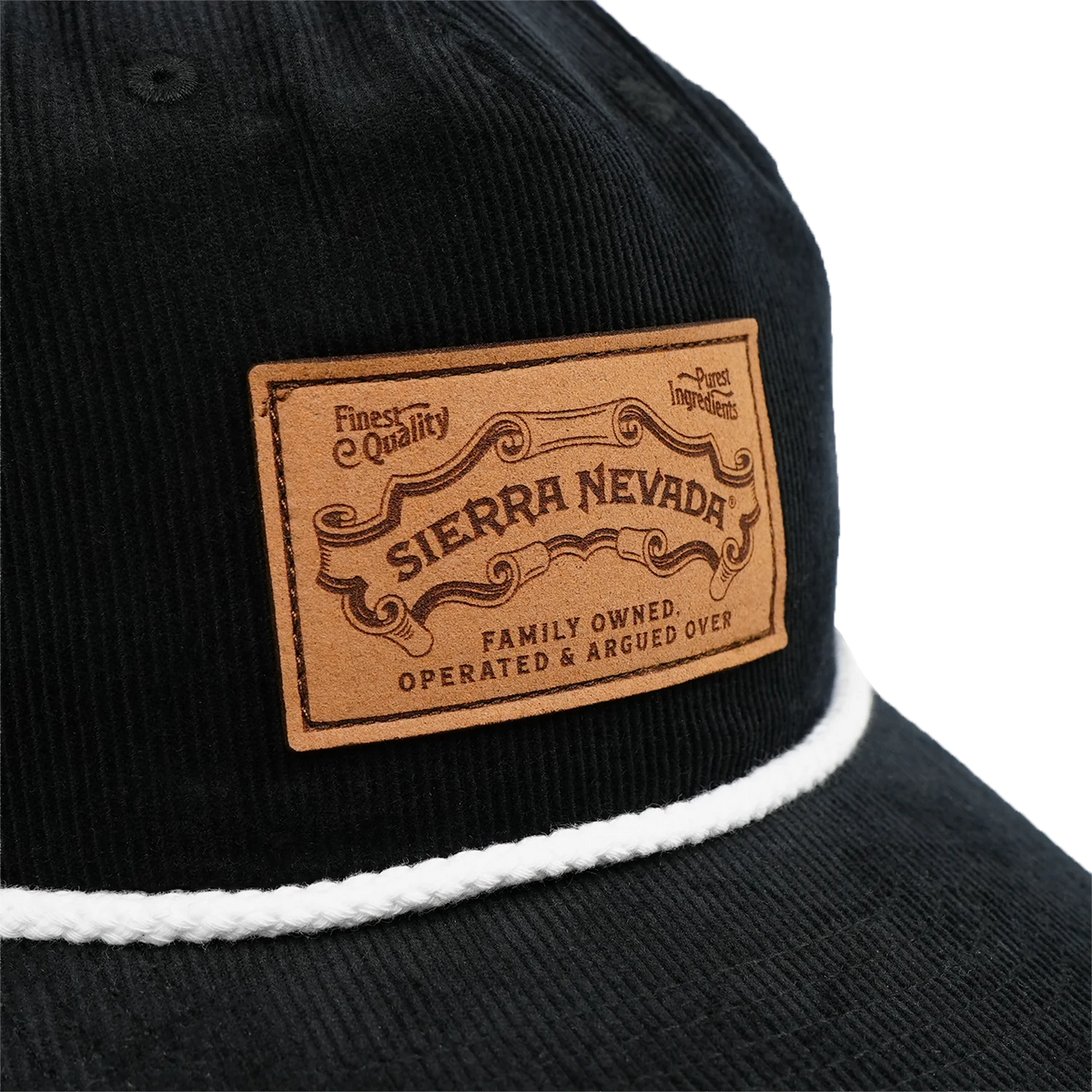 Close-up of a black corduroy cap with a white rope trim and a tan leather patch reading 'SIERRA NEVADA' on a white background.