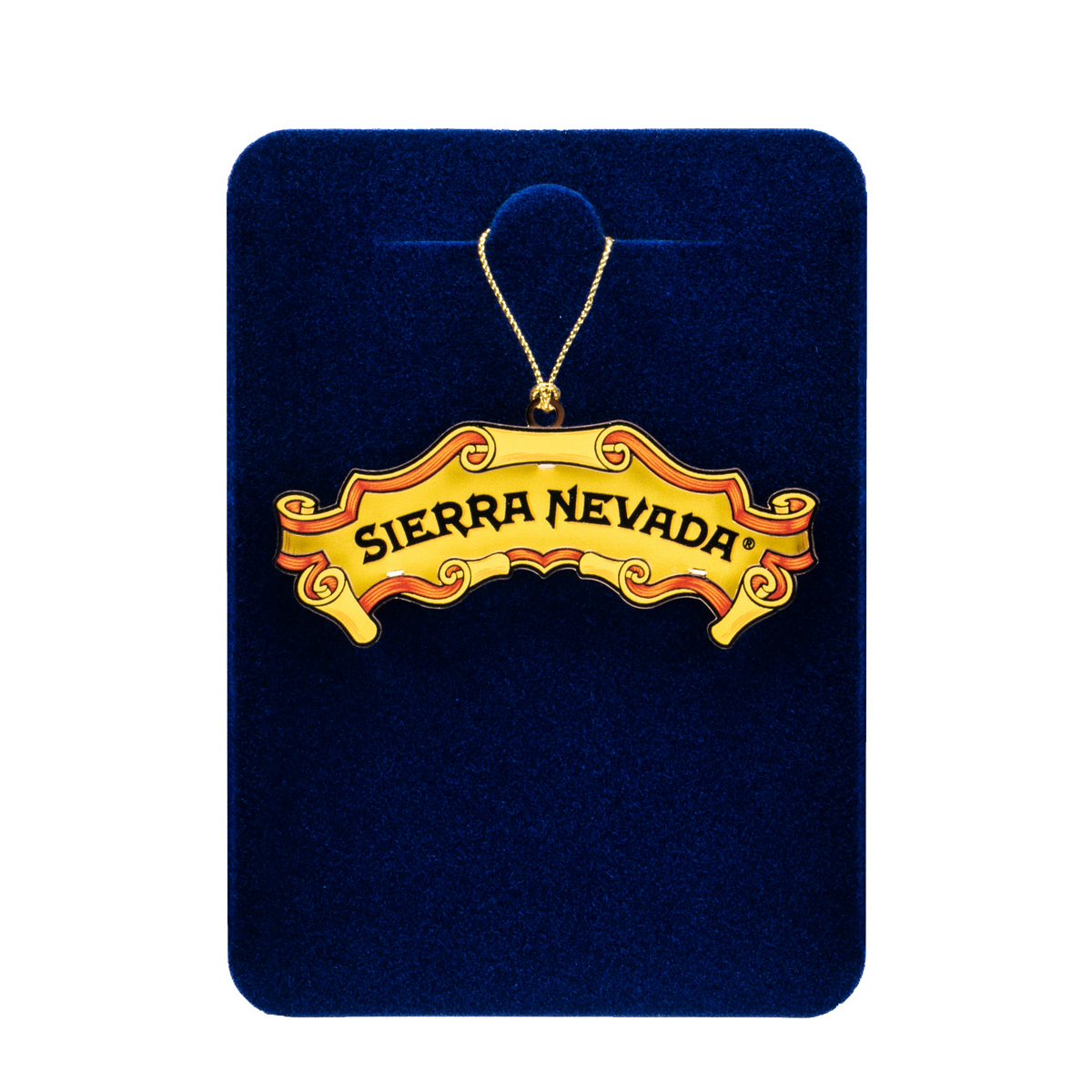 A gold-tone 'Sierra Nevada' banner ornament necklace displayed on a dark blue velvet backing card against a white background.