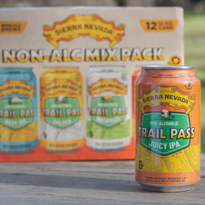 Thumbnail of A can of Trail Pass Juicy IPA sitting in front of the Trail Pass Variety Pack packaging