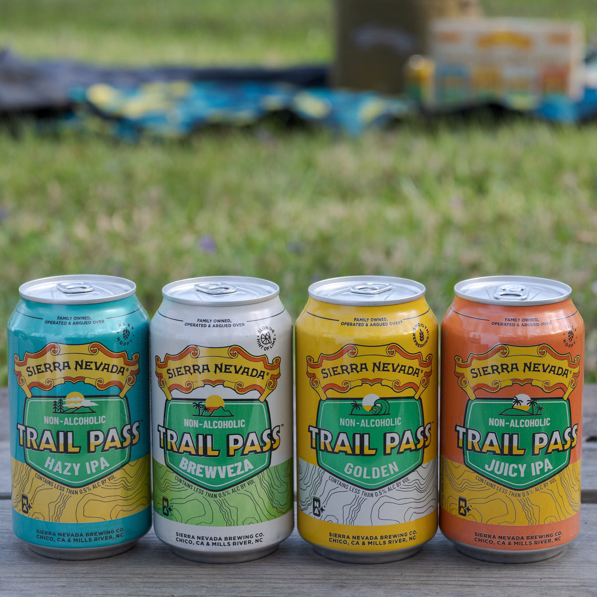 The four can styles included in the Sierra Nevada Trail Pass Variety Pack, in a lineup on a table outside