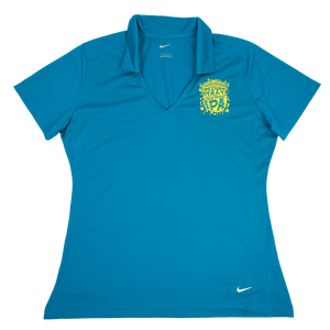 Thumbnail of A women's short-sleeve polo shirt in bright teal blue, featuring a yellow and white crest on the left chest and a small white Nike swoosh on the lower right hem.