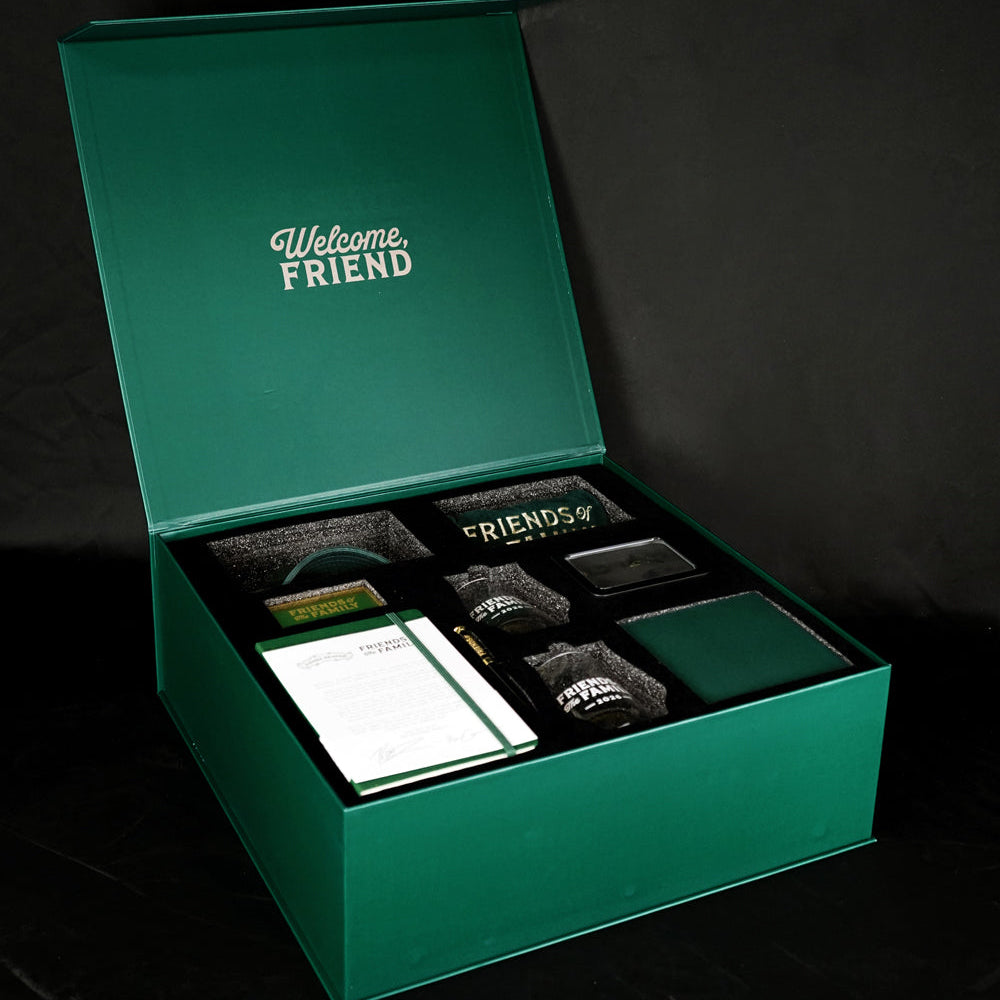 Green gift box with stationery items on a black background