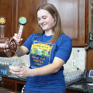 Thumbnail of Sierra Nevada Pale Ale - Porter - Stout short sleeve blue t-shirt worn in a brewery by a woman filling a beer glass from the tap